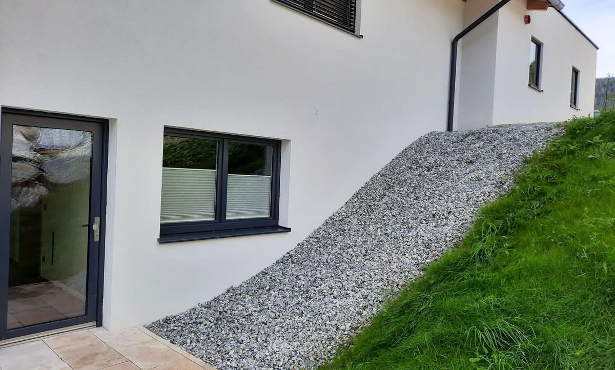 Seitenansicht mit Steinschützung und Hang